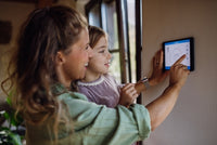 Woman and child looking at a digital display on a wall